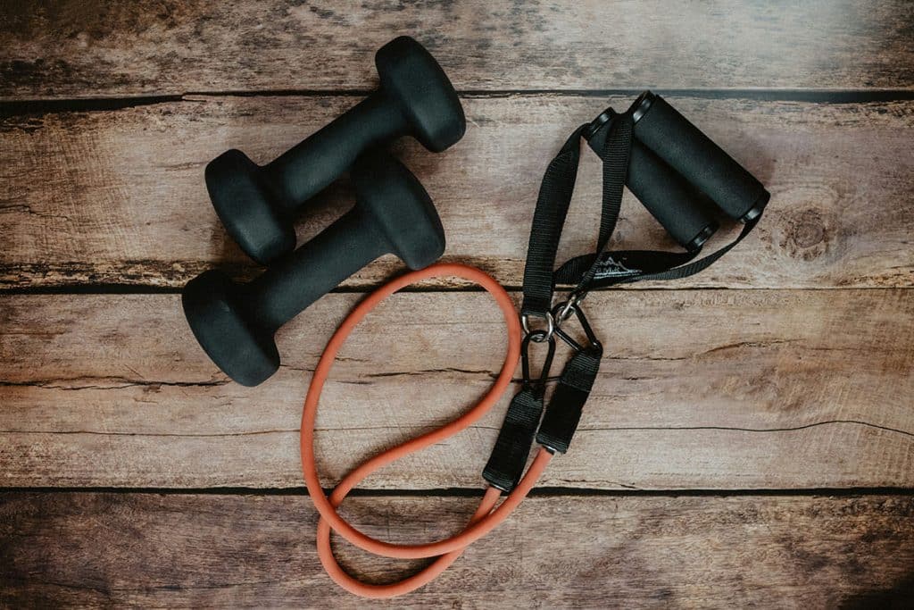 Resistance training band and small weights on a wooden floor